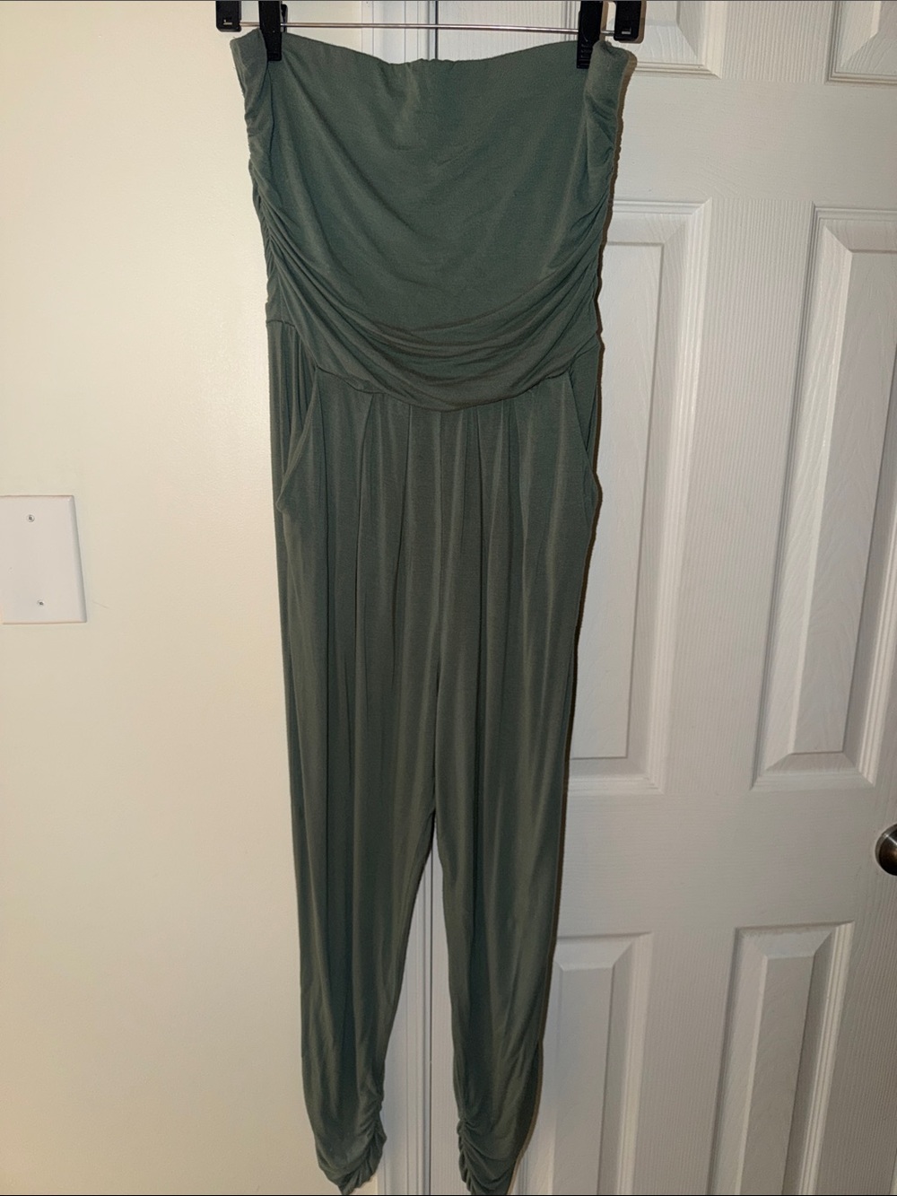 This sage green strapless jumpsuit features a flattering shirred tube top bodice